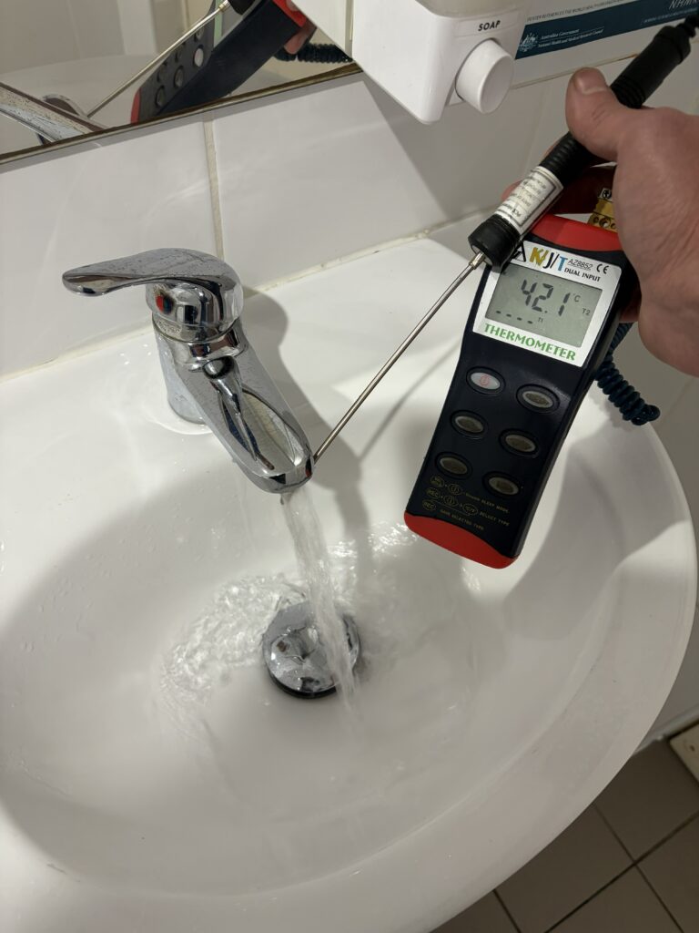 taking temperature of a basin with a digital thermometer