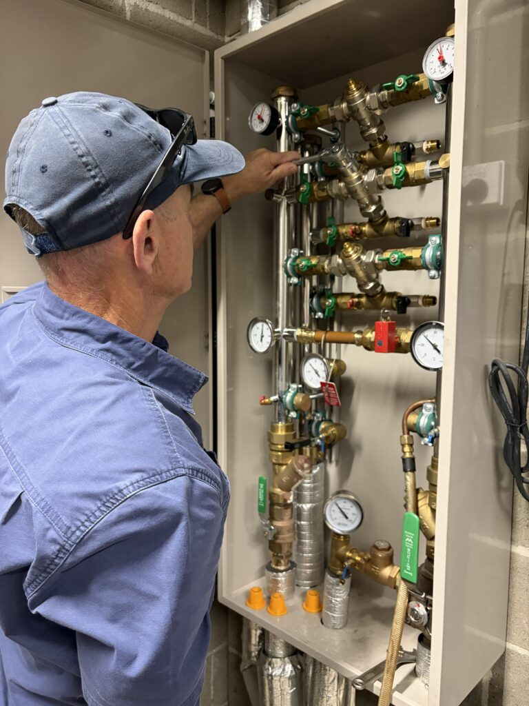A man serviceing a califfe warm water system
