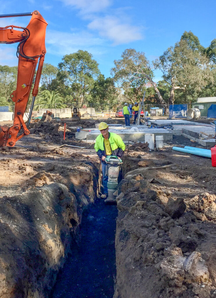 Man working on a job site using a compactor